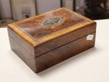 a small wooden box on a table with a clock on it