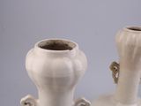two white vases sitting next to each other on a table