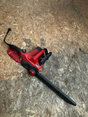 un ventilateur rouge posé par terre, muni d'une poignée noire