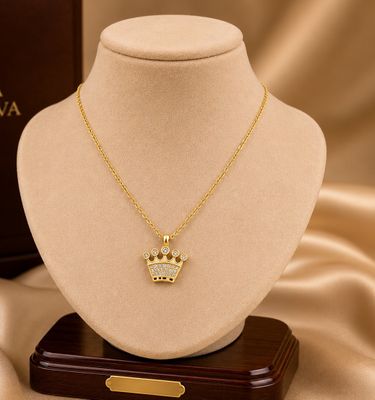 a gold necklace with a crown pendant on a mannequin