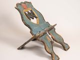 une vieille chaise en bois sur laquelle est peint un homme assis