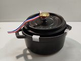 a close up of a black pot with a red, white, and blue ribbon on it