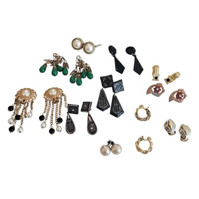 a group of assorted earrings sitting on top of a white surface