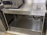 une cuisine équipée d'une table en inox et d'une cuisinière
