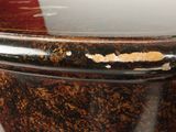 a close up of a toilet seat with peeling paint on it