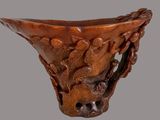 a wooden vase with carvings on it on a gray background
