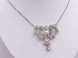 silver necklace with a heart shaped pendant and a pearl and diamond pendant