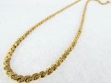 a close up of a gold chain necklace on a white surface