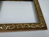 a picture of a gold picture frame on a white table