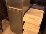 une photo d'une cuisine avec un réfrigérateur et une poubelle