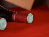 two bottles of wine sitting on a red cloth