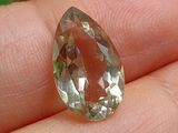 une personne tenant un diamant vert et jaune dans la main