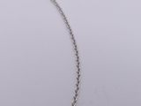 a close up of a silver necklace with a chain on a white surface