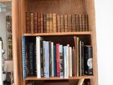 a book shelf with many books and a computer on it