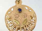 un pendentif en or orné d'une pierre bleue au centre