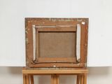 an old picture frame sitting on top of a wooden easel