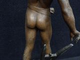 a bronze statue of a man holding a pair of scissors