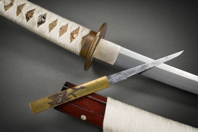 un couteau posé à côté d'un autre couteau sur une table