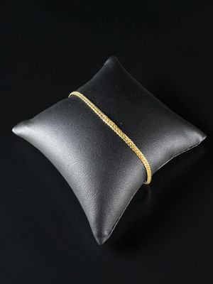 un coussin en cuir noir orné d'une chaîne dorée