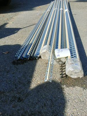 un tas de tiges métalliques posées par terre à côté d'un camion