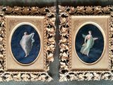 Deux tableaux encadrés représentant une femme et un homme sont accrochés au mur.