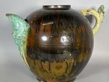un vase marron et vert orné d'un oiseau
