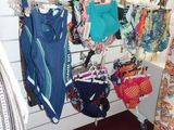 a woman standing in front of a rack of clothing