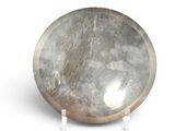a silver plate on a stand on a white surface