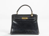 a black leather handbag with gold hardware on the handle