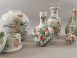 five vases and two cups sitting next to each other