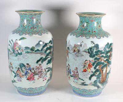 pair of chinese vases with figures on them sitting on a white surface