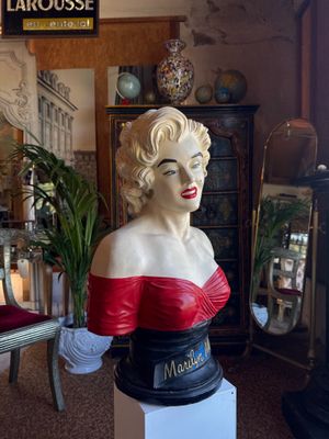 a busturine of a woman in a red dress in a room