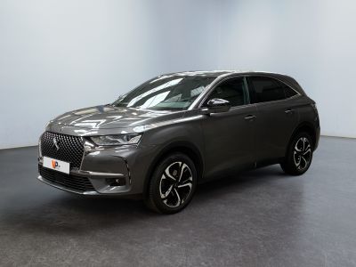 un SUV gris garé dans une pièce aux murs blancs
