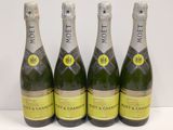 Trois bouteilles de champagne Moët sont alignées sur une table