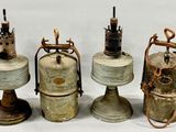 Trois bouteilles de gaz à l'ancienne sont alignées sur une surface blanche