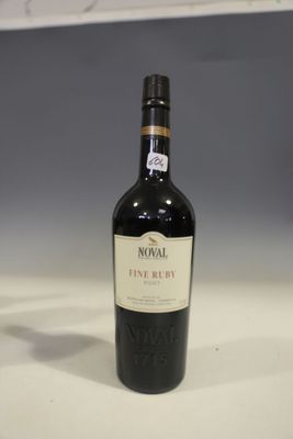 une bouteille de vin posée sur une table à côté d'un verre de vin