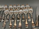 a lot of spoons and forks laid out on a table