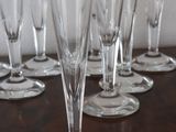 several empty wine glasses are lined up on a wooden table