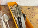 a yellow container filled with silverware on a table