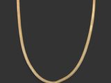 un collier en or avec une chaîne serpent sur fond noir