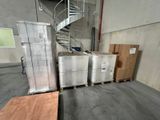 many boxes and pallets in a warehouse with a spiral staircase