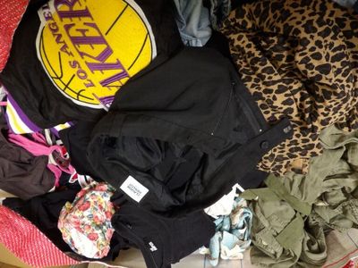 a pile of clothes that is sitting on a bed