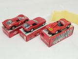 three red toy cars sitting on top of a box next to a piece of paper