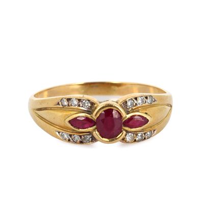 gros plan d'une bague en or avec un rubis et des diamants