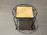 une petite table avec un plateau en carrelage posée sur un sol carrelé