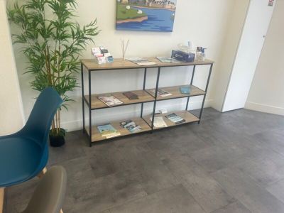 a picture of a living room with a book shelf and a blue chair