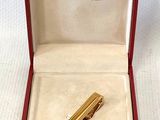 an image of a gold tie bar in a red box