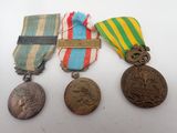 three medals are sitting on a table with a ribbon around them
