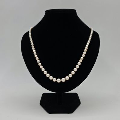 un collier de perles blanches sur un mannequin noir