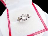a diamond ring in a red box on a white plate